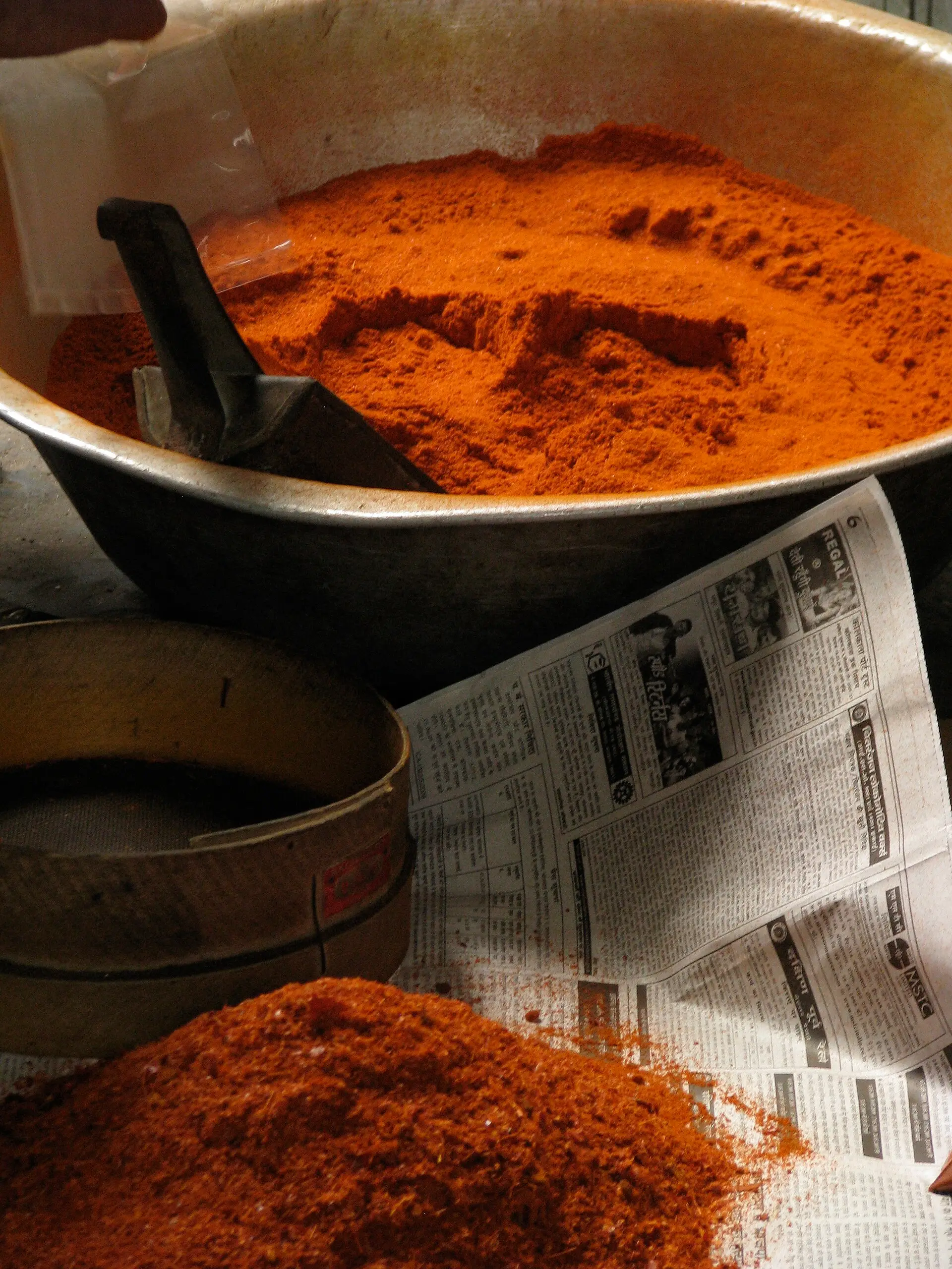Heaps of red chili powder in brass pans at a spice shop in Kolkata